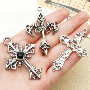 Close-up of vintage gothic cross pendants in aged silver alloy for necklace DIY