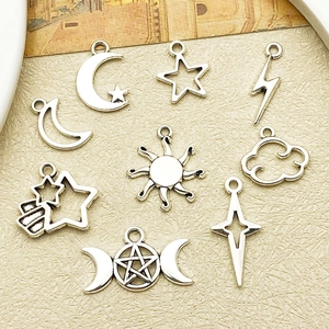 Dettaglio di ciondoli vintage in argento con motivi luna, sole e stelle per il fai da te