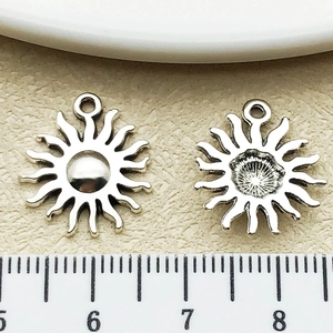 Dettaglio di ciondoli a forma di sole in lega d'argento con anello e righello di misura