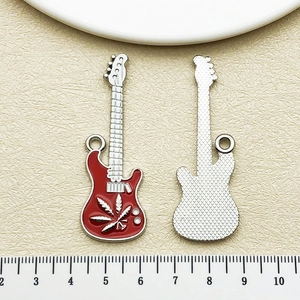 Détail macro du pendentif guitare avec émail rouge et envers métallique texturé