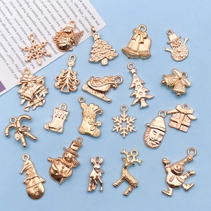 Flat lay of gold Christmas charms including snowman, reindeer and tree for DIY jewelry