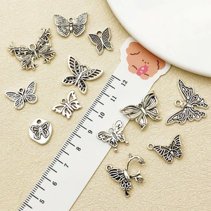 Macro view of vintage silver hollow butterfly charms with measurement ruler for DIY jewelry