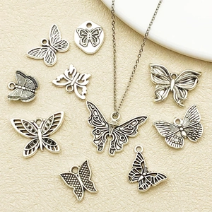 Detailed flat lay of assorted vintage silver butterfly pendants for DIY jewelry making