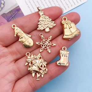 Close-up of golden Christmas snowman and reindeer charms for DIY jewelry making