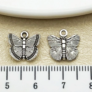 Detailed macro view showing antique silver butterfly pendant size with measuring ruler