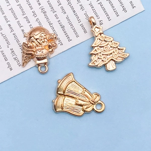 Detailed macro of rose gold Christmas charms including tree and bell for DIY jewelry