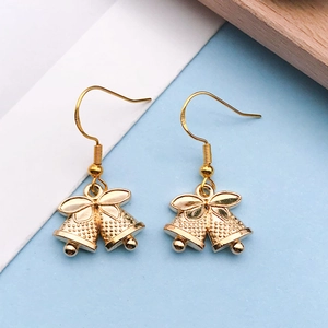 Detailed macro view of S925 sterling silver gold-plated Christmas bell earrings with bow