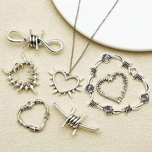 Gros plan de pendentifs cœur en alliage argenté vintage avec motifs punk roses