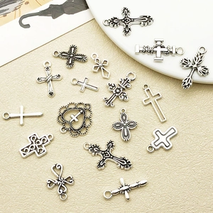 Vue détaillée de breloques croix en argent antique aux designs vintage ajourés