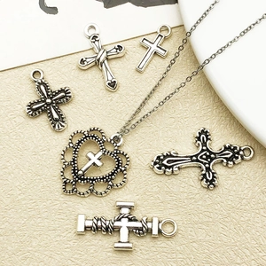 Gros plan de pendentifs croix vintage et breloques coeur en alliage argent pour bijoux