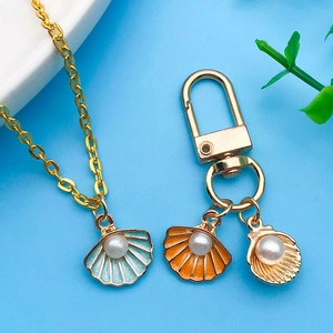 Vue détaillée des pendentifs coquillage avec perles et chaînes en alliage plaqué or