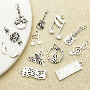 Antique silver musical instrument and note charms including guitar and treble clef set