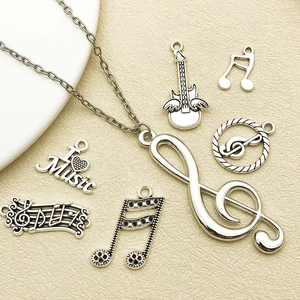 Macro view of antique silver music pendants including G-clef and I Love Music charms