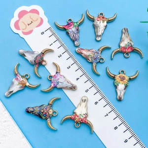 Vue détaillée de pendentifs tête de taureau bohème avec règle pour comparer la taille