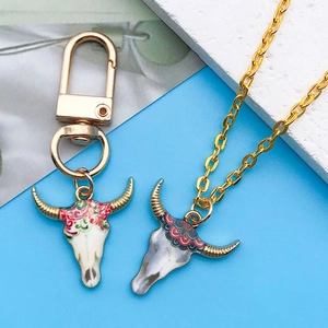 Détail du porte-clés et collier tête de taureau de style bohème en or émaillé