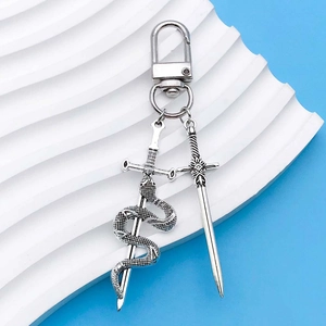 Detailed macro of antique silver sword and snake charms on a metallic d-ring keychain