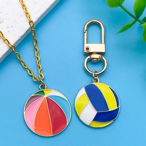 Primer plano de colgantes de voleibol coloridos en cadenas doradas sobre fondo azul vivo