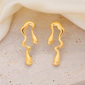 Detalle de pendientes dorados con diseño de metal líquido sobre piedra y satén