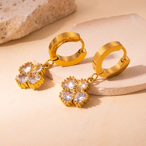 Detailed macro shot of 18K gold-plated clover earrings featuring heart-shaped zircons