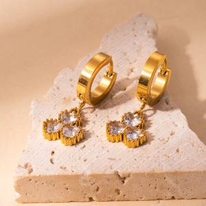 Detailed shot of 18K gold plated clover earrings with heart shaped clear zircons