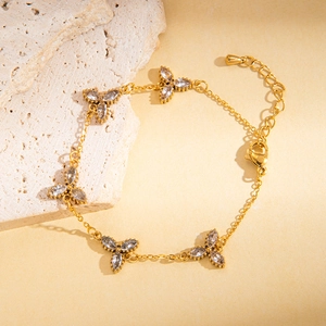 Dettaglio del bracciale dorato in acciaio al titanio con cinque pendenti a forma di fiore