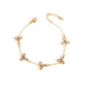 Detail eines Gold-Titanarmbands mit fünf Blumenanhängern und Marquise-Strasssteinen