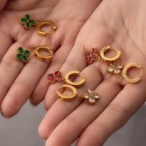 Detail of 18K gold plated clover earrings set with emerald green and ruby red cubic zirconia