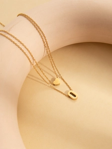 Detailed macro view of gold-plated double-layer necklace with heart and letter O pendants