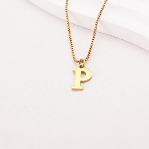 Macro shot of gold box chain necklace featuring a minimalist letter P pendant
