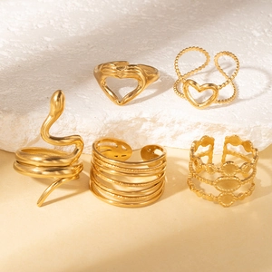 Detail view of five-piece gold ring set featuring snake and heart motifs on a stone base