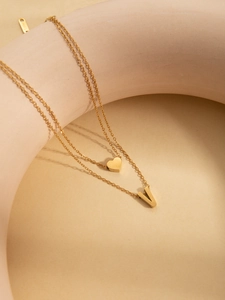 Close-up of double-layer gold titanium steel necklace with V-letter and heart pendants