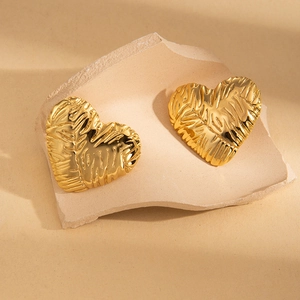 3D textured heart stud earrings in 18K gold plated stainless steel on stone props