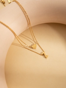 Detail of double-layer gold plated necklace with polished heart and letter Z pendants