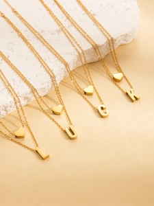 Detail of gold-plated titanium necklace with LUCK letter charms and heart pendant
