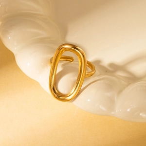 Detail view of a vintage gold titanium ring on a wavy white ceramic plate with artistic shadows