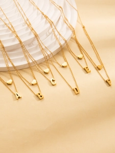 Macro view of double-layer gold plated initial necklaces A-F with heart pendants