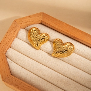 Polished gold plated heart earrings with hammered texture finish in a jewelry display box