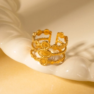 Detailed macro view of gold-plated stainless steel ring with tiered geometric patterns