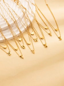 Macro shot of gold-plated titanium steel double layer necklaces with letter pendants