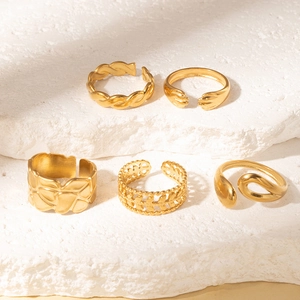 Detail view of five assorted gold-tone vintage stackable rings on stone display base