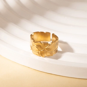 Detail of gold titanium ring showing unique irregular geometric texture and matte finish