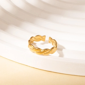 Detail view of gold twisted rope ring on geometric stand with minimalist design