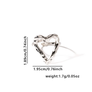Détail d'une bague réglable en forme de cœur argentée avec texture métallique martelée