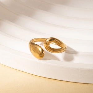 Detail of a vintage golden teardrop adjustable ring on a white tiered display stand