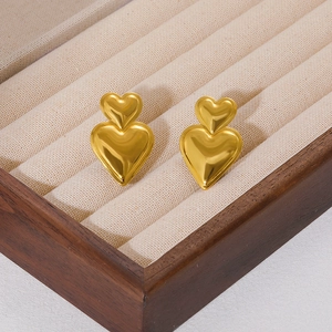 Elegant 18K gold plated double heart earrings with high polish on a jewelry tray