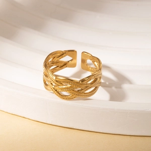 Detail view of a vintage gold braided titanium steel open ring with woven texture
