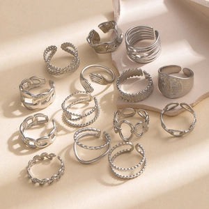 Close-up of vintage silver-tone ring set featuring hug hand and religious relief designs