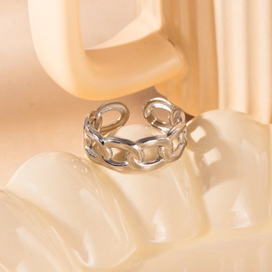 Macro shot of a silver Cuban link hollow ring on a minimalist ceramic tray detail