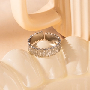 Macro view of silver adjustable ring with beaded dot texture on ceramic tray