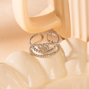 Detailed macro of a silver triple-layer beaded open ring with a circular bezel setting